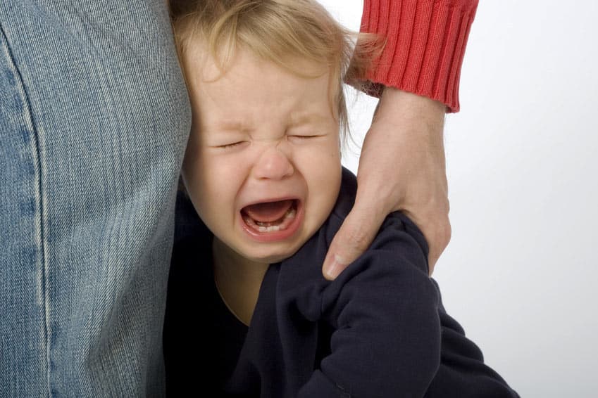Un enfant hyperactif pleure à la main de sa mère