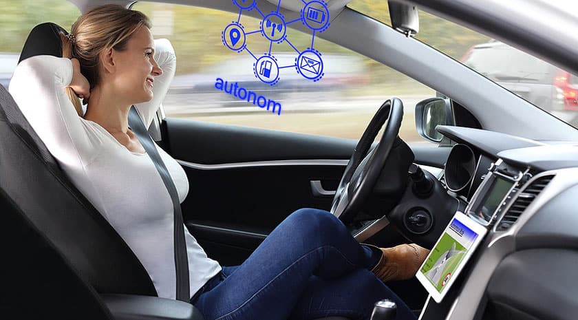 Une femme est assise dans une voiture autopilotée équipée de la technologie 5G.