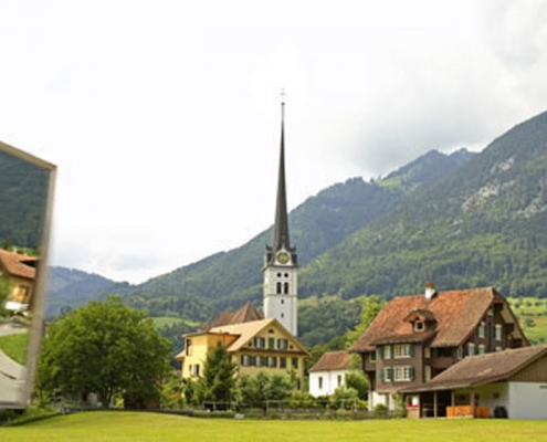 L'église d'Alpnach avec une prairie verte au premier plan.