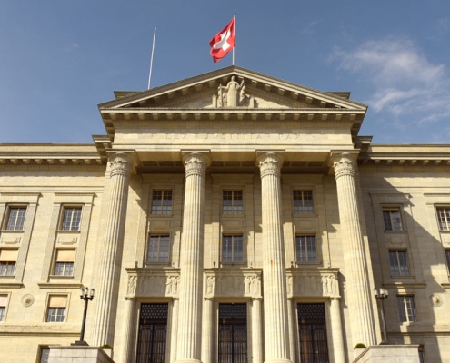 Das Bundeshaus in Bern mit Schweizer Flagge auf dem Dach.