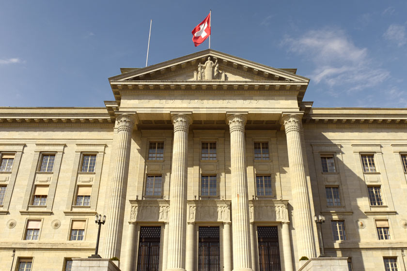 Das Bundeshaus in Bern mit Schweizer Flagge auf dem Dach.