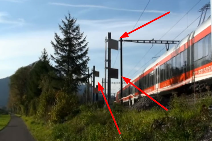 Un train sur une voie ferrée, des flèches rouges pointent vers des antennes émettrices 5G mobiles.