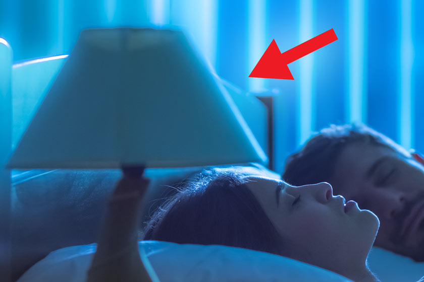 Un homme et une femme sont allongés dans un lit près d'une lampe.
